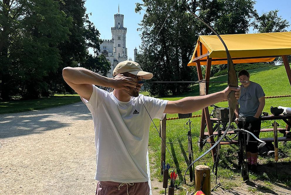 Mann zeigt mit Pfeil und Bogen 